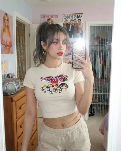 AI-generated: {
  "subject": {
    "description": "person from the reference images take a mirror selfie",
    "expression": "confident and slightly playf
