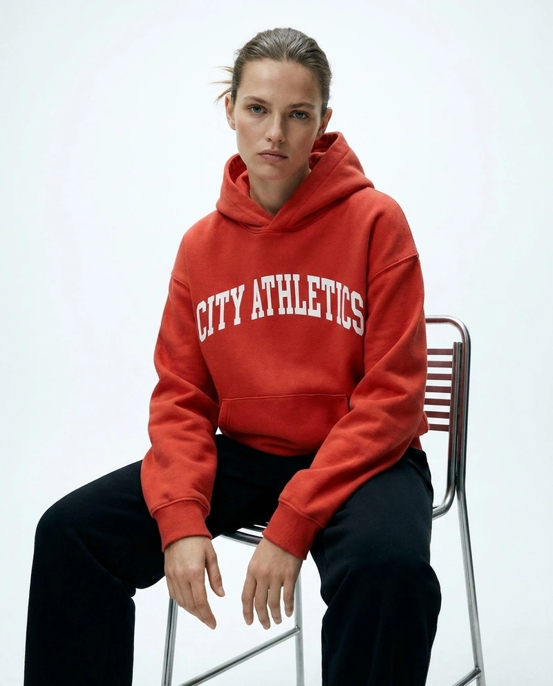 AI-generated: The model from the reference images wearing the @baba, sitting on a high chair. Studio shoot.